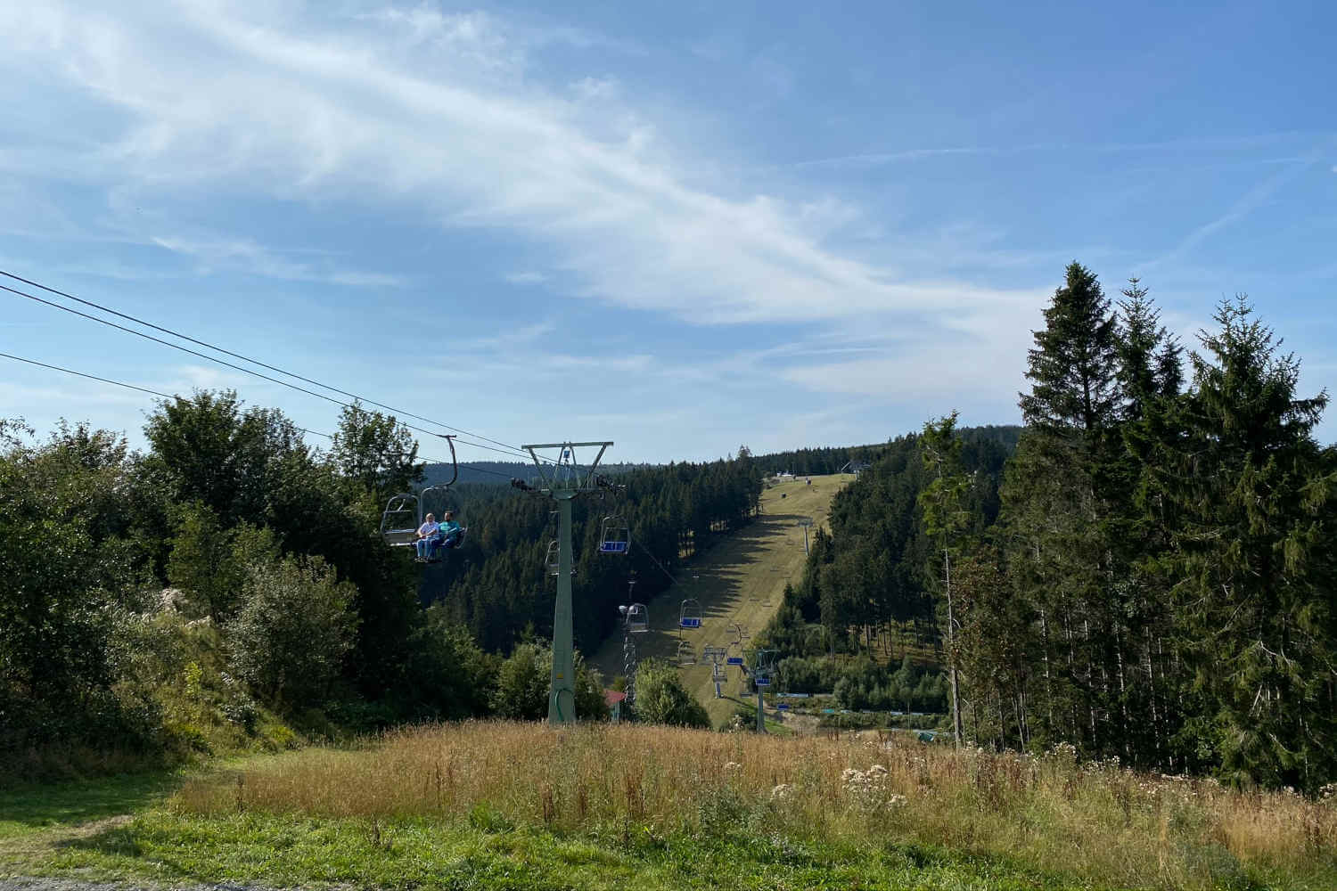 Menschen fahren mit dem Sessellift hinauf zur Sprungschanze in Winterberg